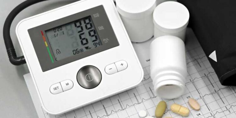 Blood pressure monitor with pills on ECG sheet, essential for heart health management., tags: um 60 - pexel